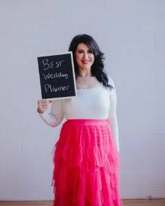 Melbourne wedding planner Gee Tankir from Gee What a Wedding holding a sign reading Melbourne’s best wedding planner