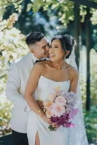 Melbourne marriage celebrant Gee leading an outdoor wedding ceremony for a couple in a garden setting
