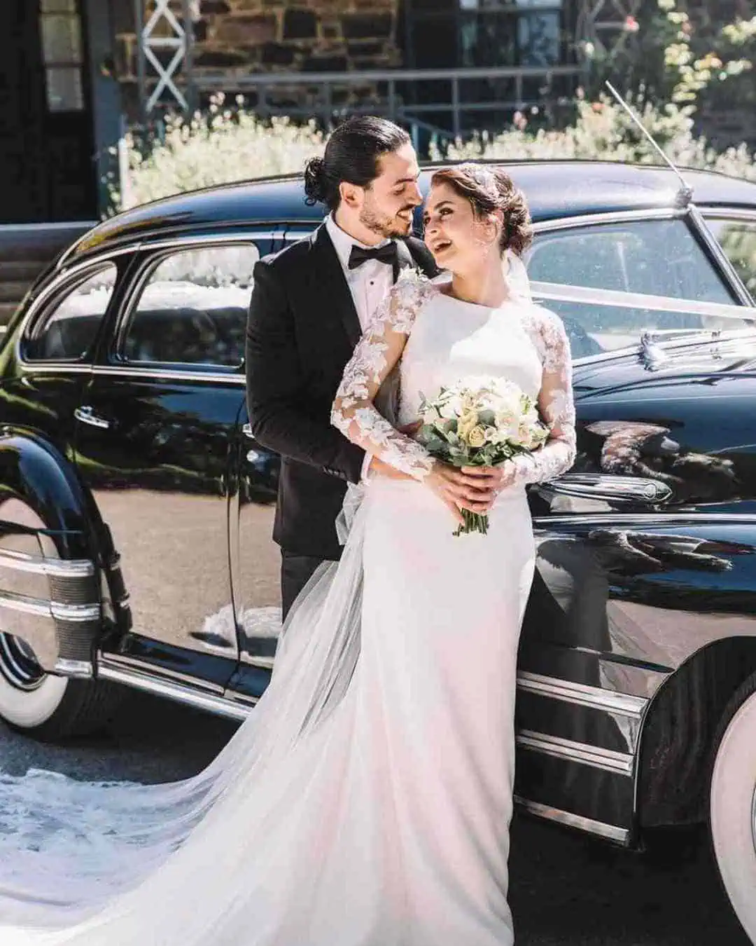 Melbourne wedding couple posing beside vintage car in a classic wedding portrait
