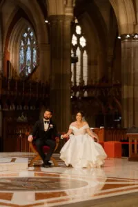 Interstate couple bride and groom seated inside St Patrick's Cathedral Melbourne during their wedding ceremony – Gee What a Wedding