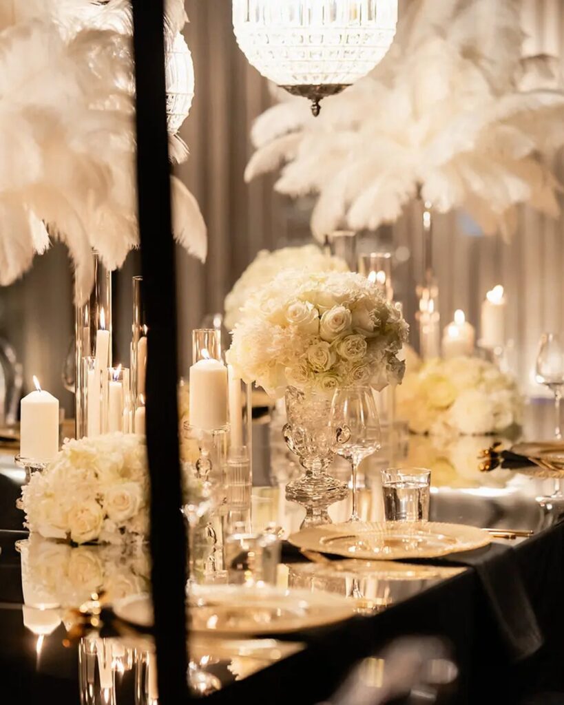 Black and gold ostrich feather event tablescape with crystal chandelier and candlelight, styled by Gee What a Wedding for a 26th birthday celebration at Strato Melbourne, Southbank rooftop